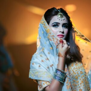 Beautiful Indian bride in traditional attire with intricate jewelry and makeup.