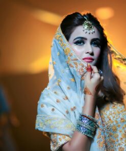 Beautiful Indian bride in traditional attire with intricate jewelry and makeup.